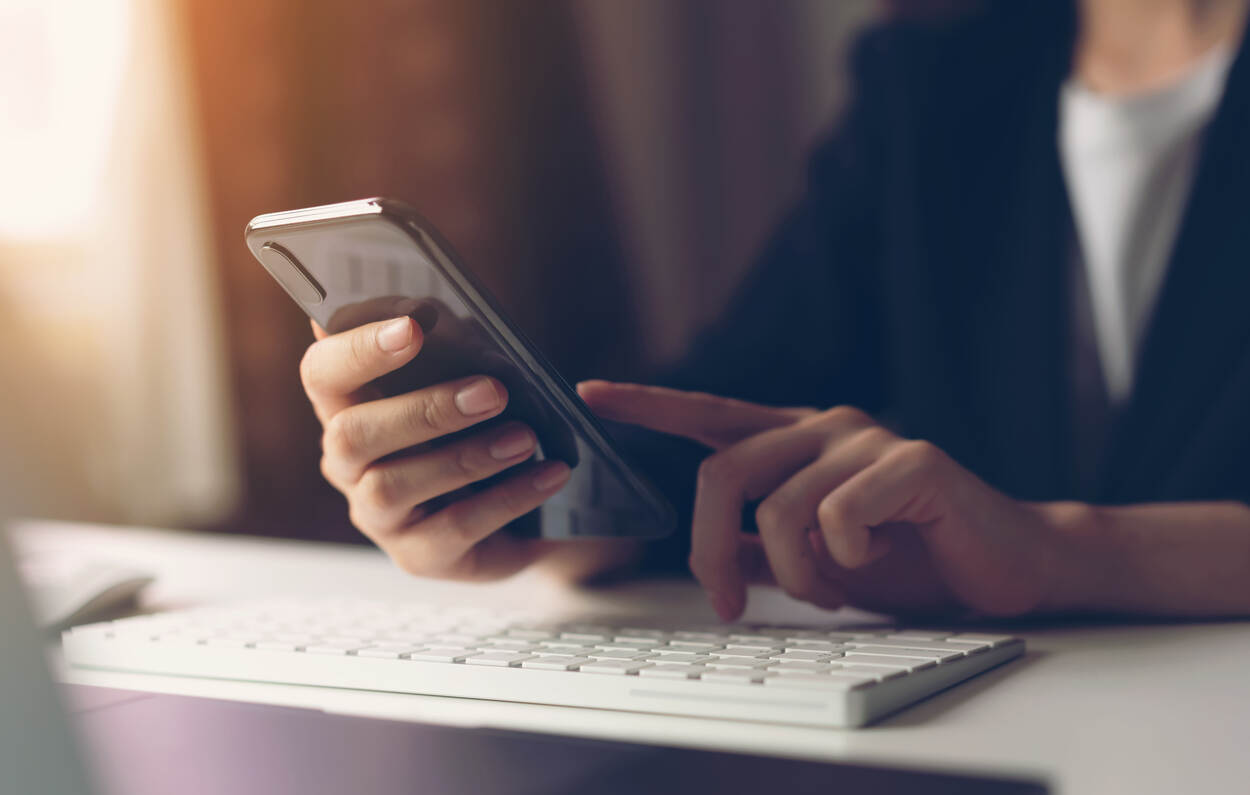 Een vrouw met een mobiele telefoon in haar hand