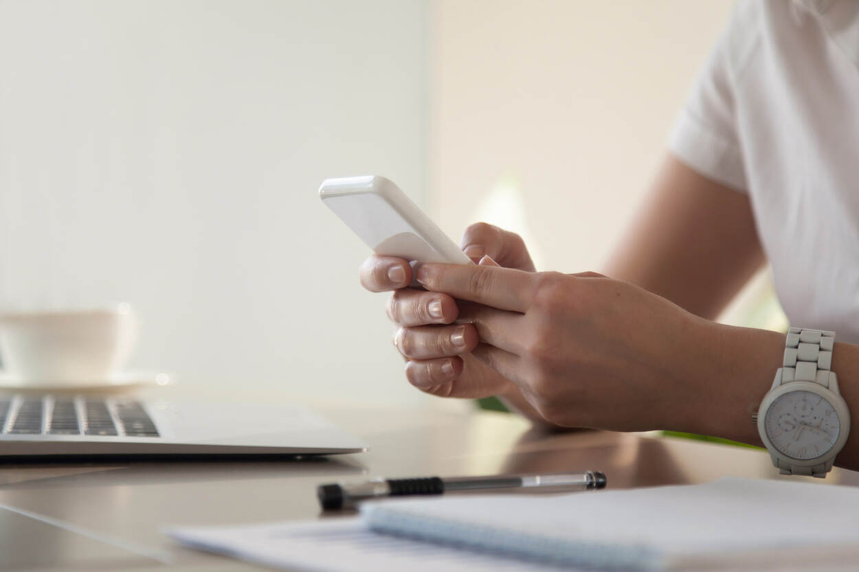 Een vrouw kijkt op haar telefoon