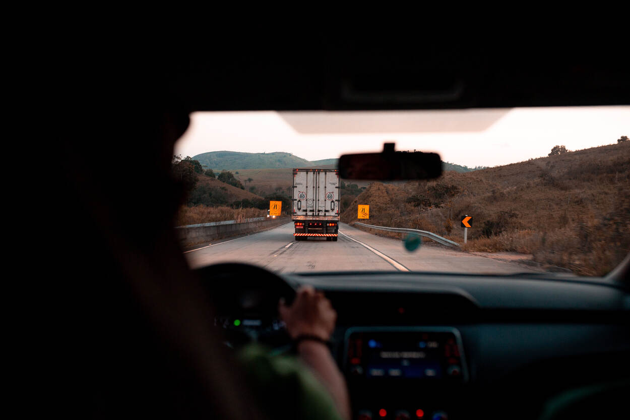 Een auto rijdt achter een vrachtwagen, vanuit het perspectief van de bestuurder van de auto gezien