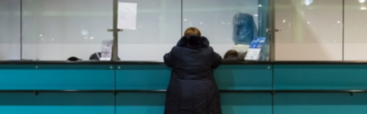 Een vrouw staat aan een balie bij de gemeente