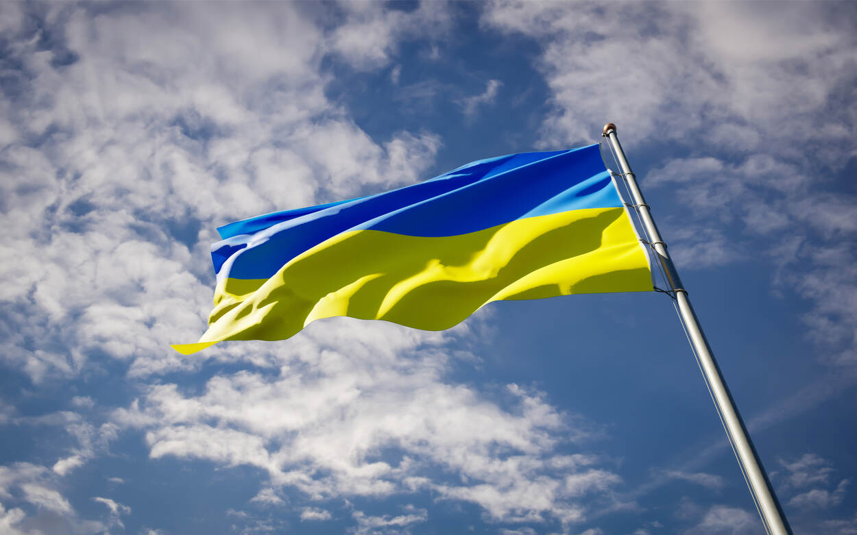De vlag van Oekraïne met een blauwe lucht op de achtergrond