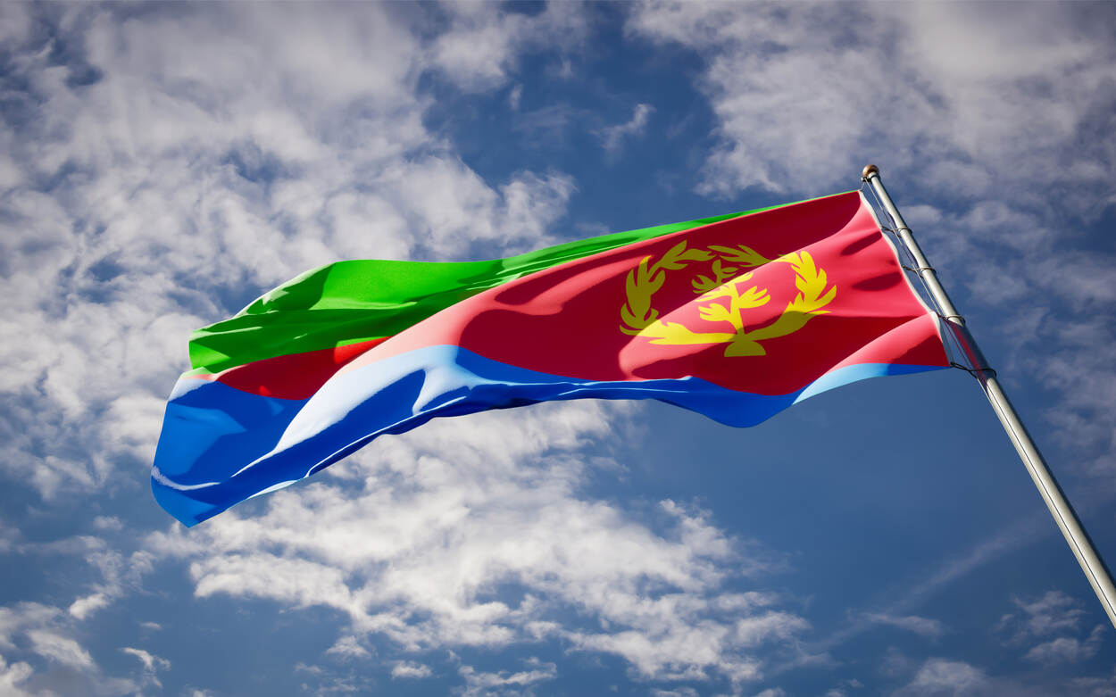 De vlag van Eritrea met blauwe lucht op de achtergrond