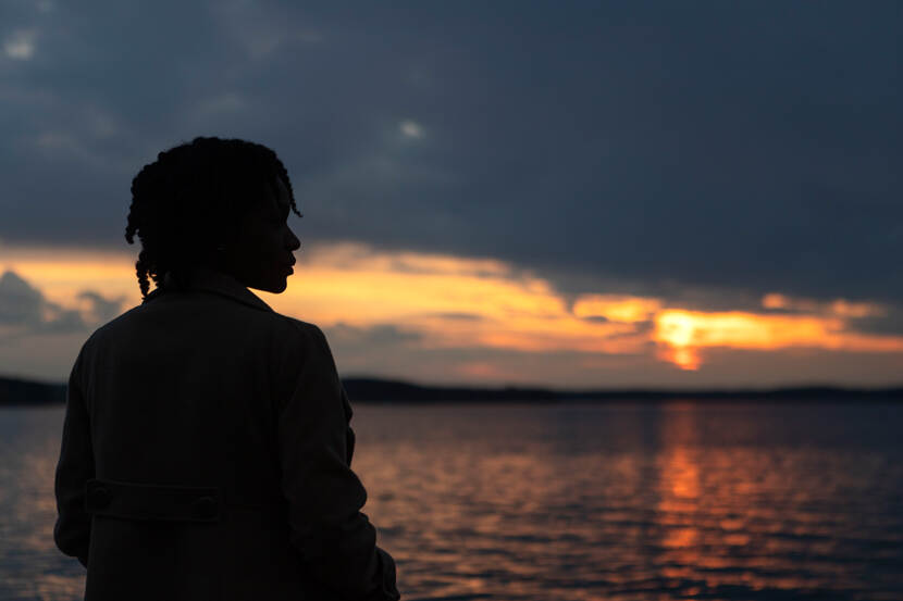 Een vrouw kijkt naar de zonsondergang